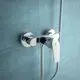 Chromene Brausearmatur von Ideal Standard an einer blauen Wand montiert. Der Wasserhahn hat einen schlichten, funktionalen Hebel zur Einstellung der Wassertemperatur.